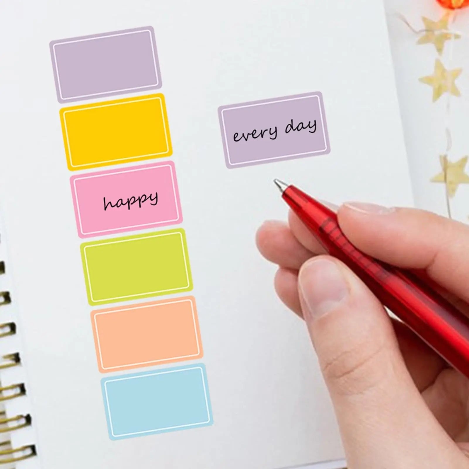 Colorful adhesive label stickers on roll being written with pen for planner and jar labeling