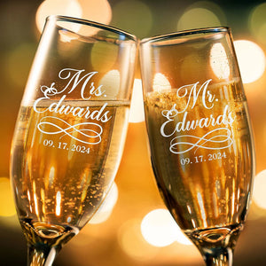 Engraved wedding champagne glasses filled with sparkling wine for bride and groom